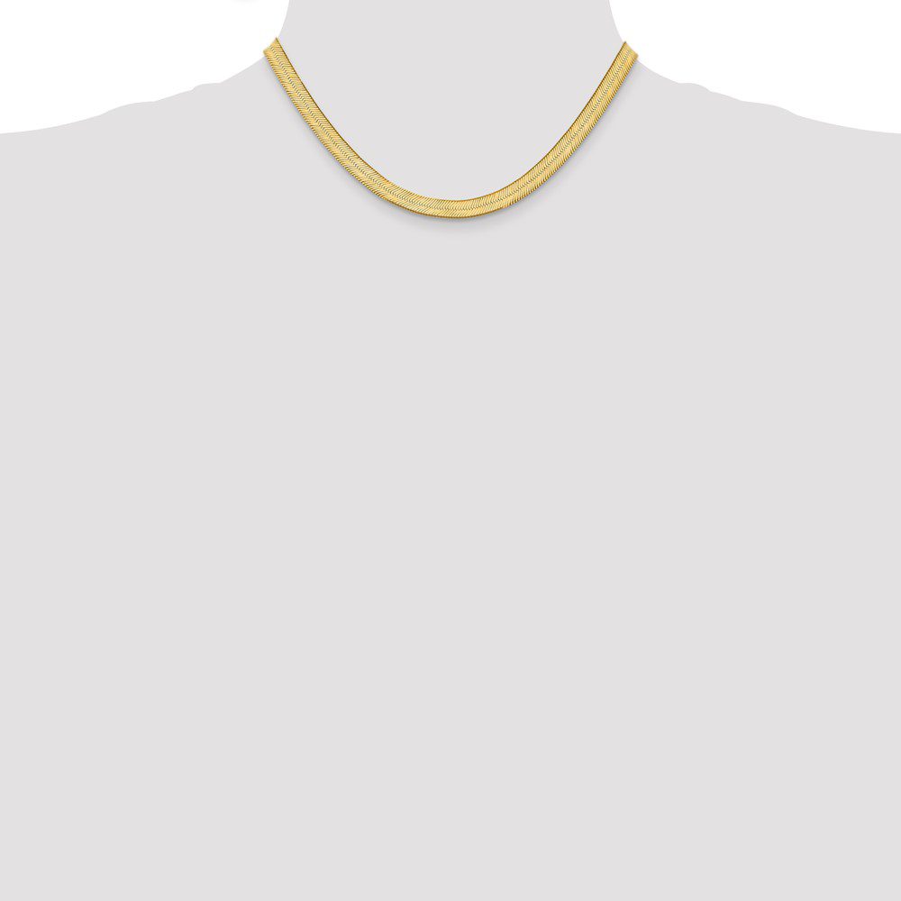 Simple gold chain necklace on a plain background.