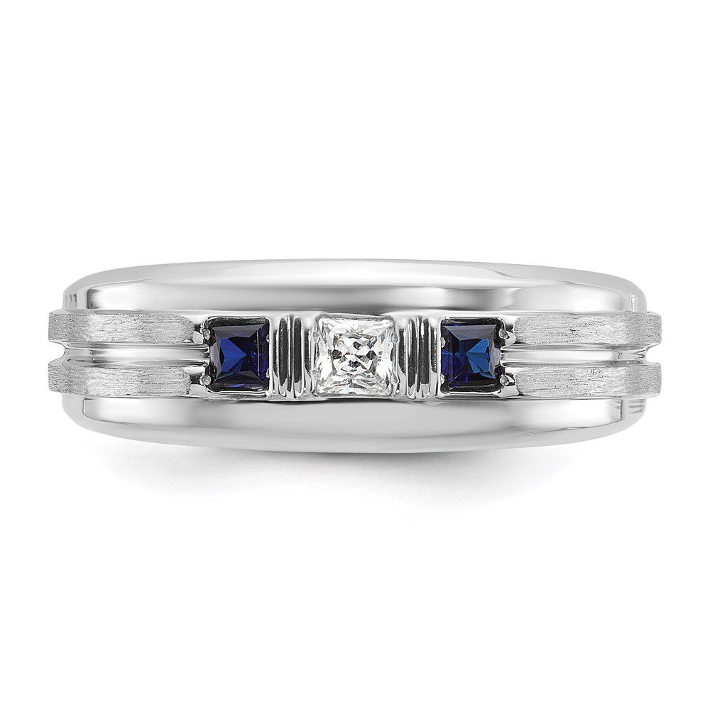 Elegant silver ring with three center stones, including two blue sapphires.