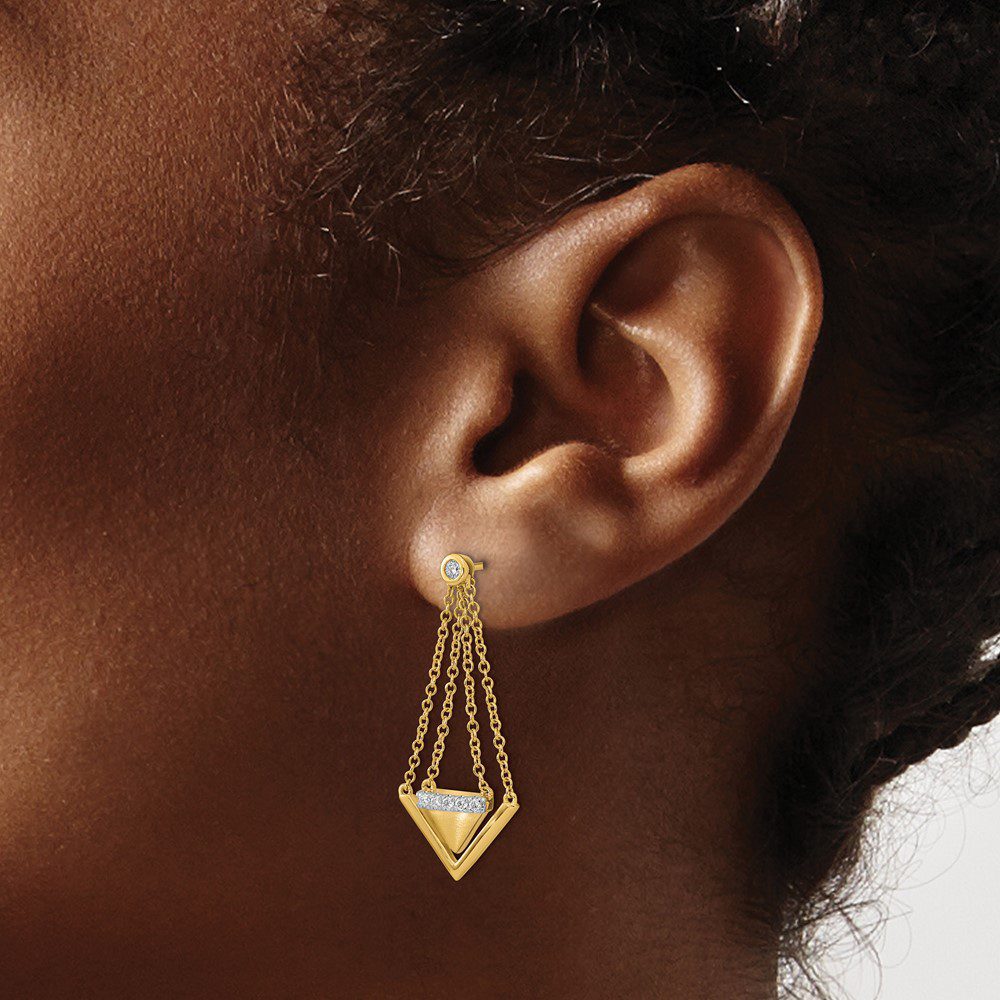Close-up of an ear wearing a geometric gold earring.