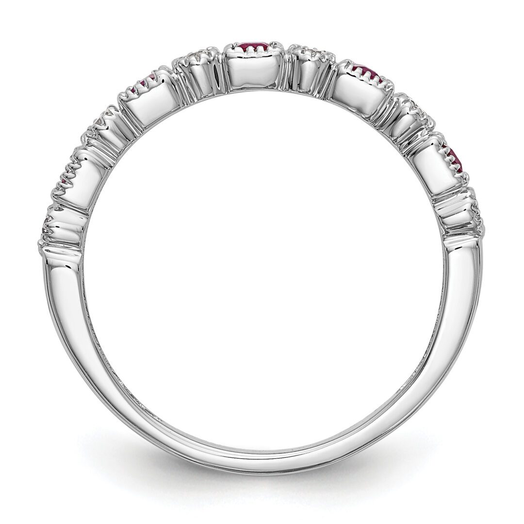 Elegant silver ring with a small red gemstone and intricate detailing.
