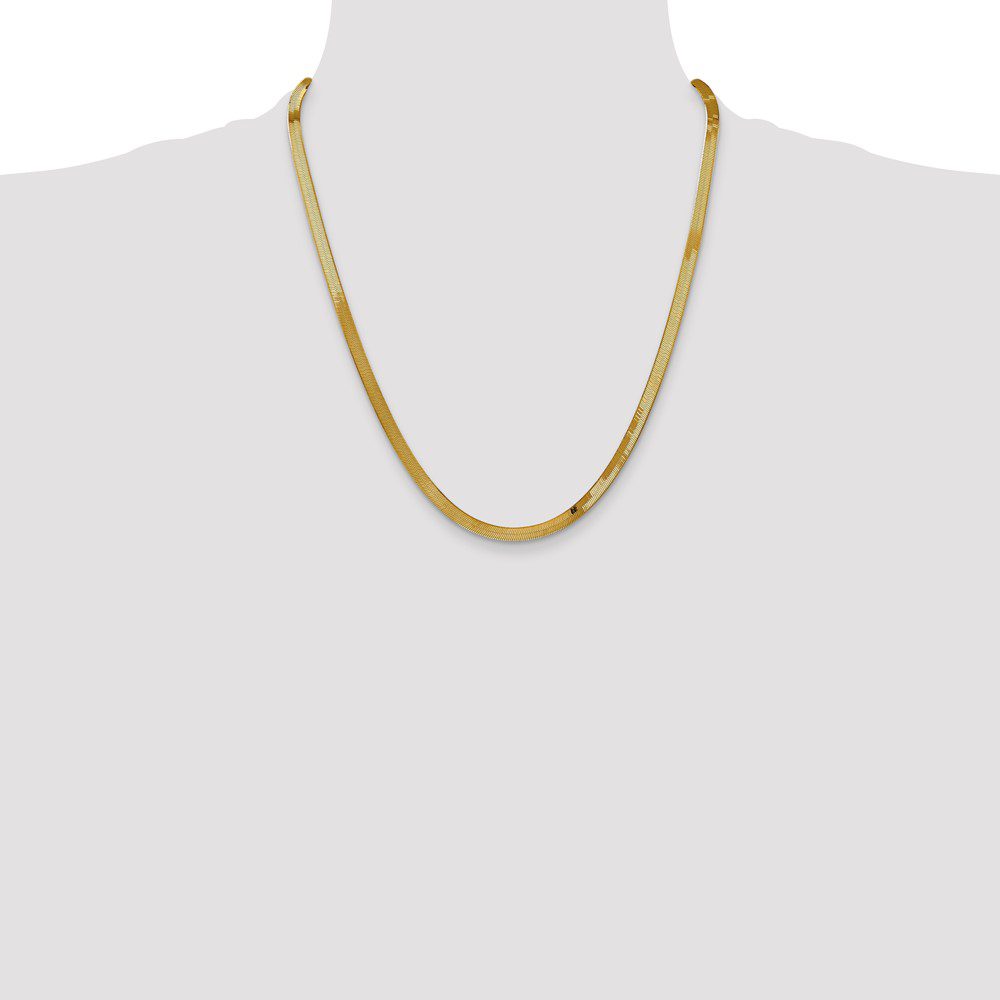 Elegant gold chain necklace on a white mannequin bust.