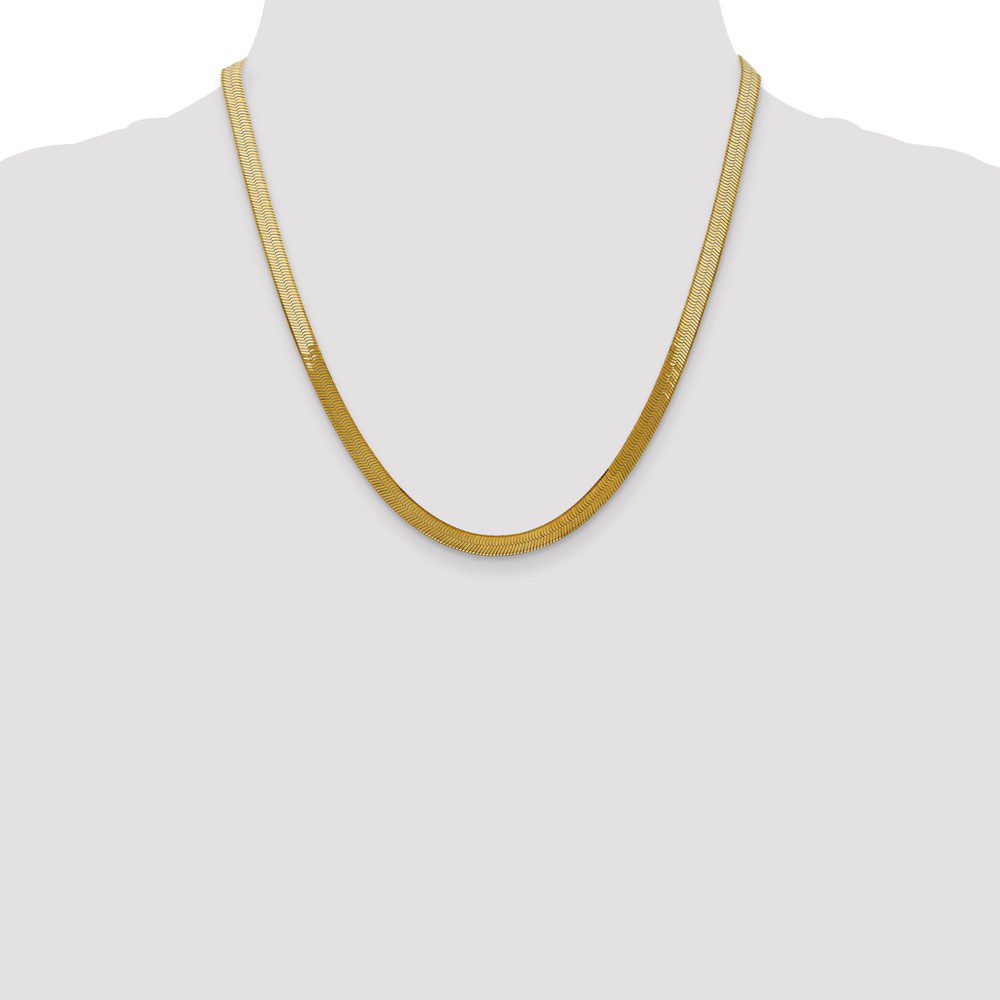 Elegant gold chain necklace displayed on a mannequin.