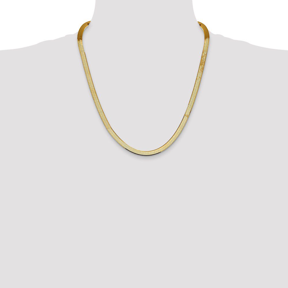 Elegant gold chain necklace displayed on a mannequin.