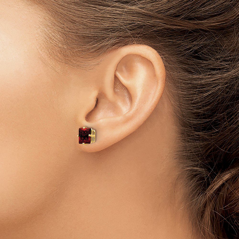Close-up of an ear wearing a square black stud earring.