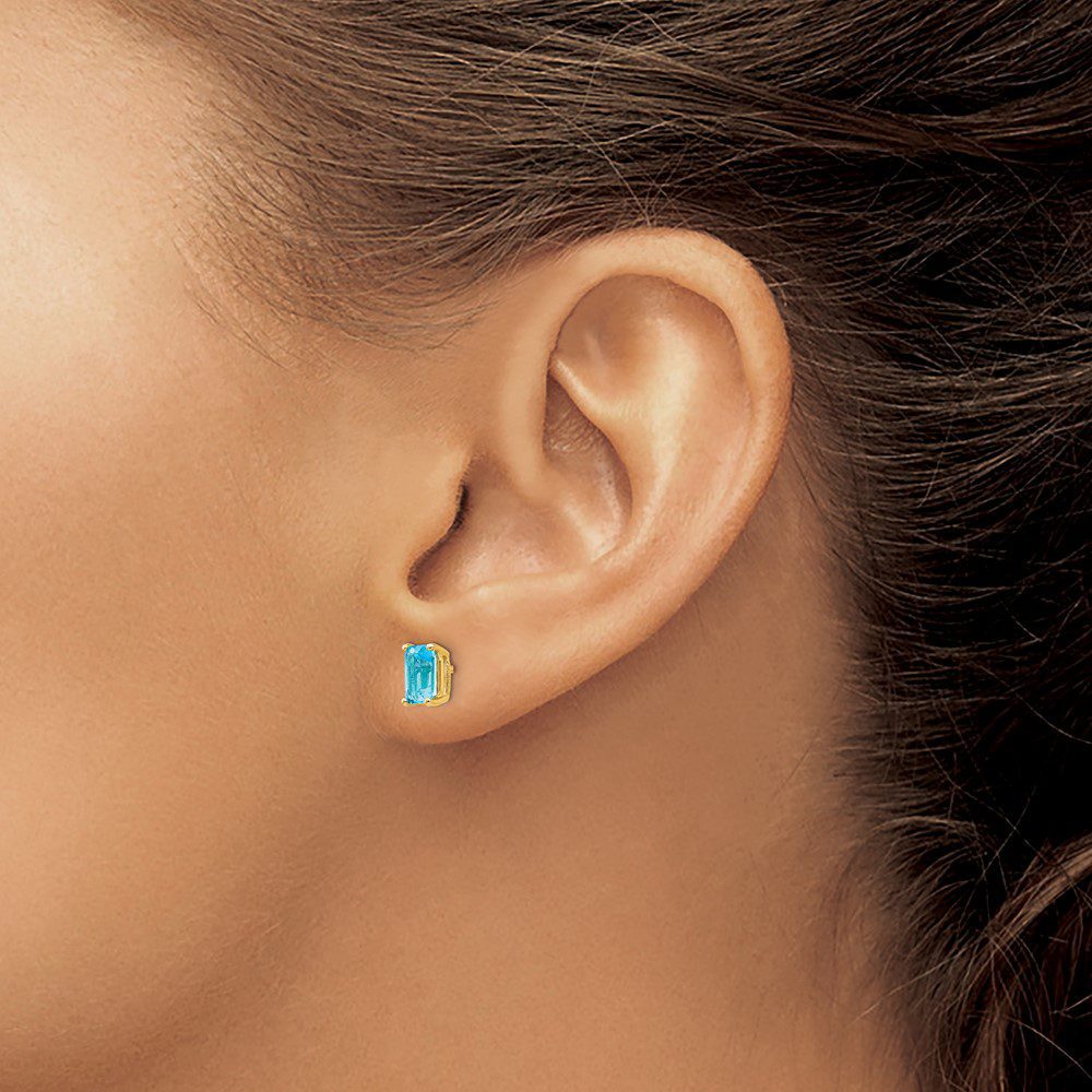 Close-up of an ear with a turquoise stud earring.