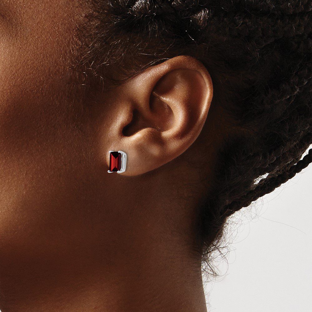 Close-up of an ear with a small, colorful stud earring.